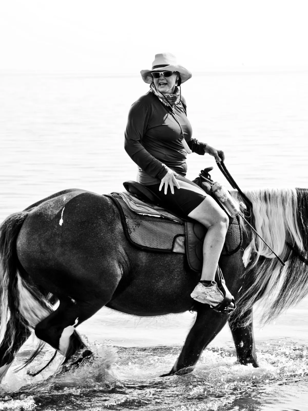 a person riding a horse in a body of water